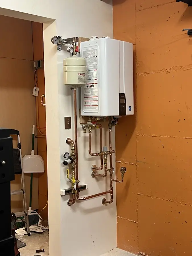 Plumbing technician inspecting water heater connections in Palm City